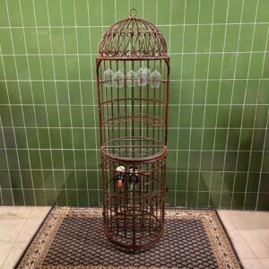 staande metalen wijnkast in vogelkooi stijl met glazenhouders en flessenrek